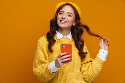 Happy young woman with long red hair in sweater, a Person Photo by Dean Drobot