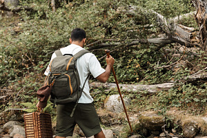 Man with backpack crossing rocky riv, a Person Photo by Perpis