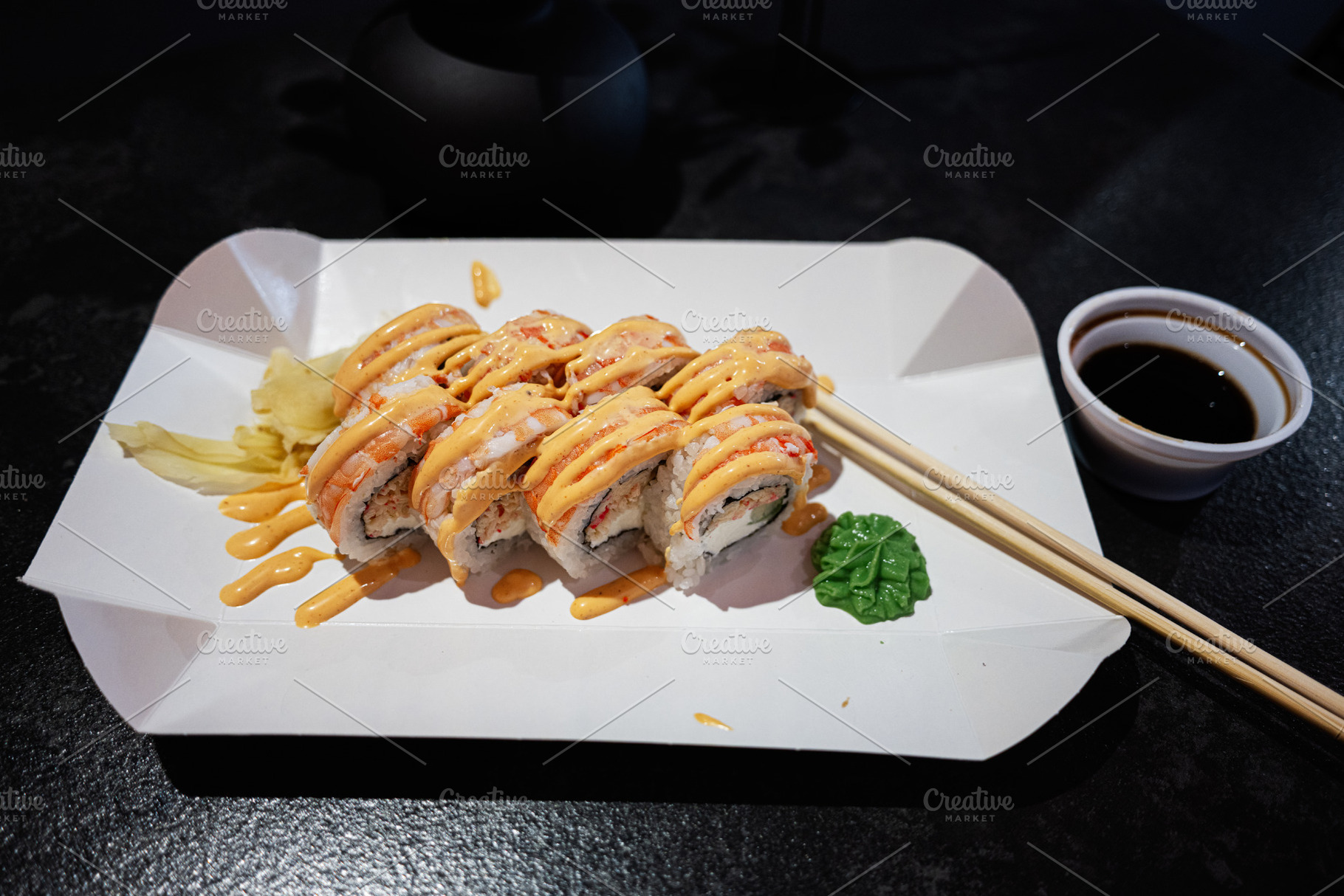 Delicious sushi roll with sauce served on a paper tray with chopsticks, a Photo by AS photostudio
