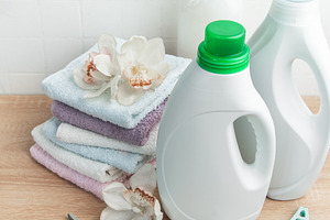 Laundry detergent and fabric softener bottles with fresh towels