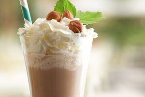 Detail of milkshake with hazelnuts and cream on a terrace, a Food & Drink Photo by Davizro's Market