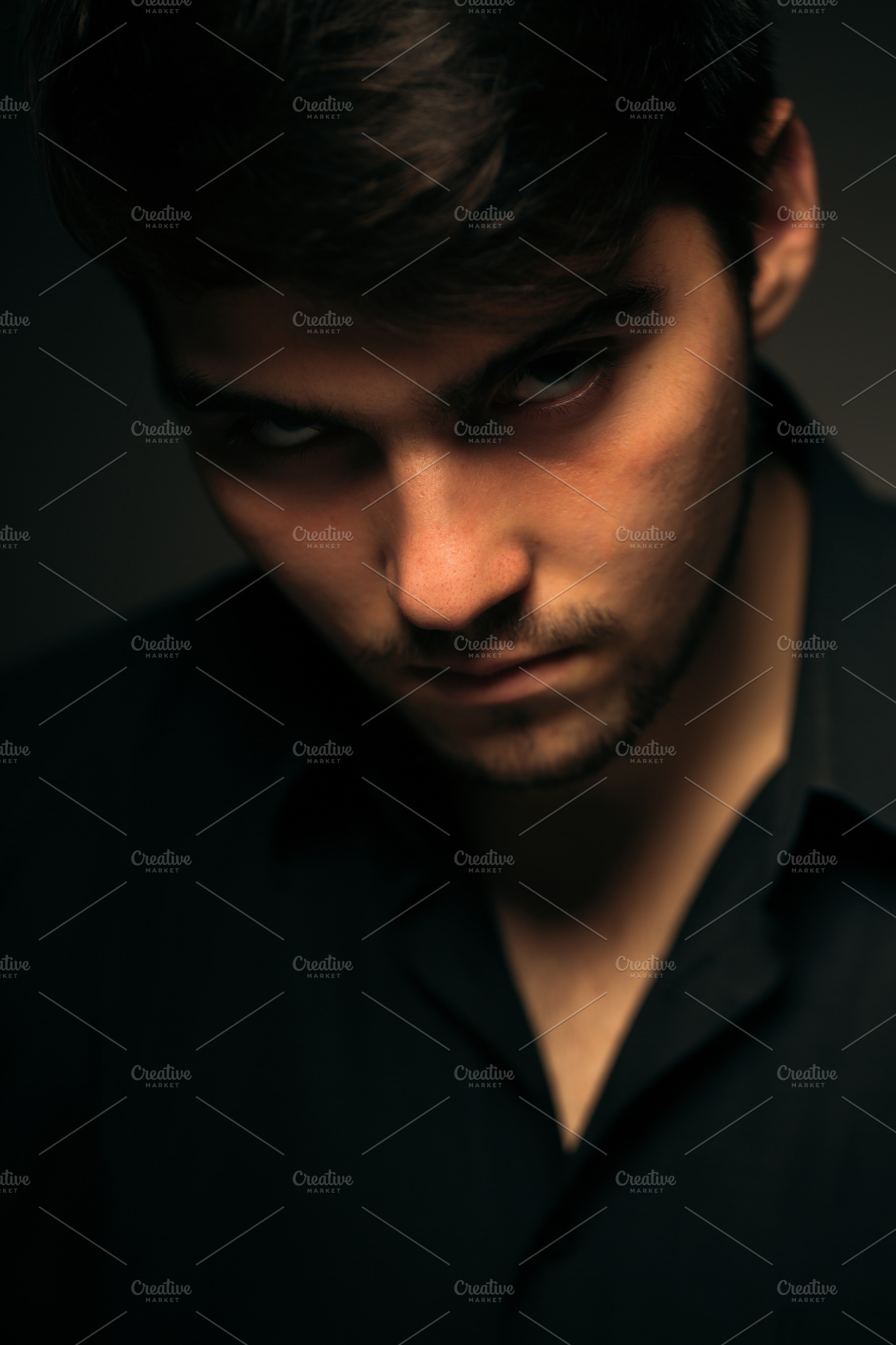 Young brunette guy on a dark background featuring fashion, male, and guy, a Person Photo by ruslan117