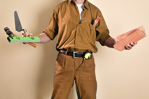Detail of mason with tools in hands isolated brown background, a Person Photo by Davizro's Market