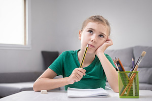Thoughtful Girl Sitting at Desk with Pencil and Notebook, a Person Photo by etorres69