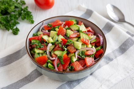 Homemade Mediterranean Cucumber Tomato Salad in a Bowl, side vie, a Food & Drink Photo by LiudmylaChuhunova