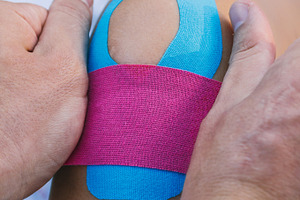 Physiotherapist putting kinesiotape stock photo containing aching and adhesive