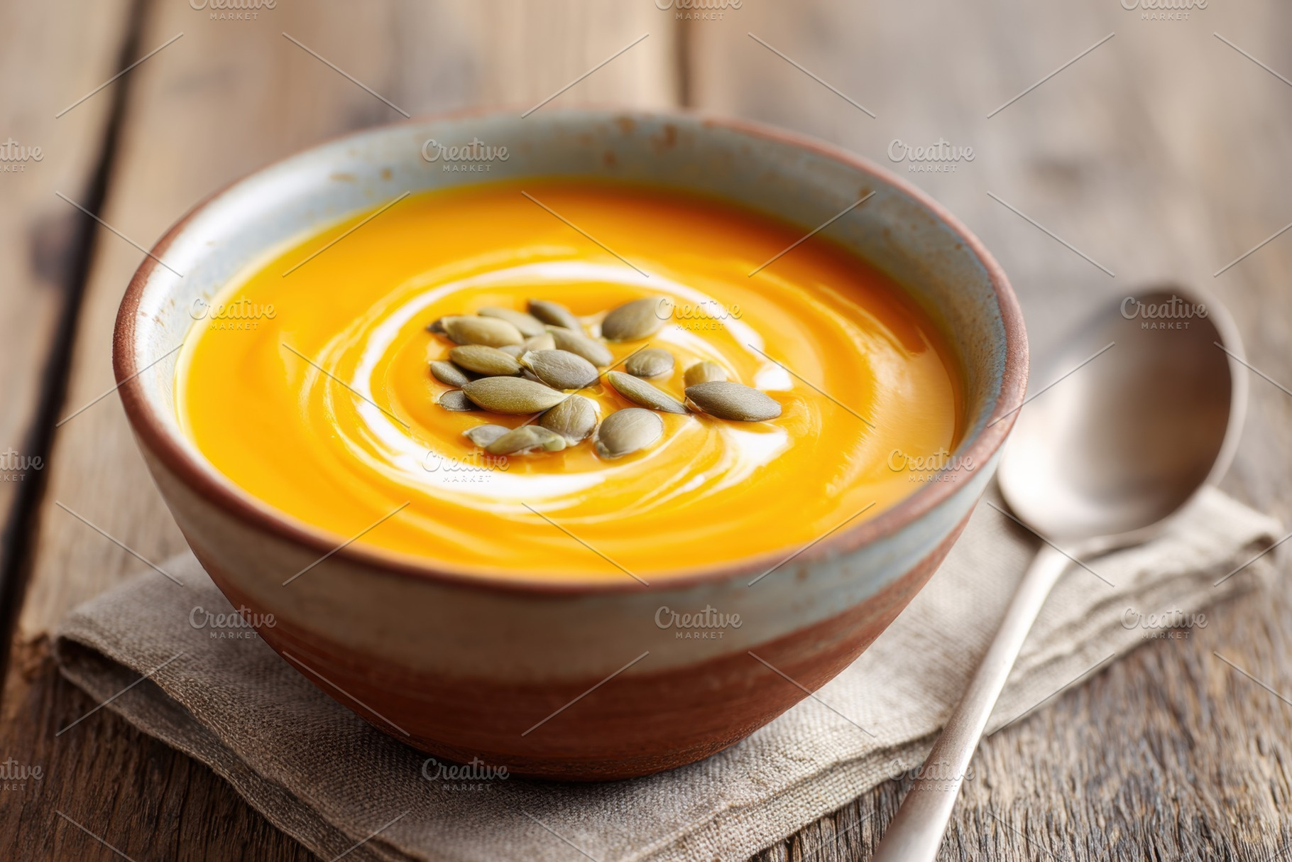 Creamy orange soup with seeds and cream swirl, a Food & Drink Photo by AlyaAnd