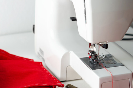 Sewing machine with red fabric, a Beauty & Fashion Photo by Pandateam