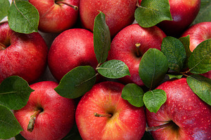 Fresh red apples forming appealing composition with green leaves, a Food & Drink Photo by Olena Rudo
