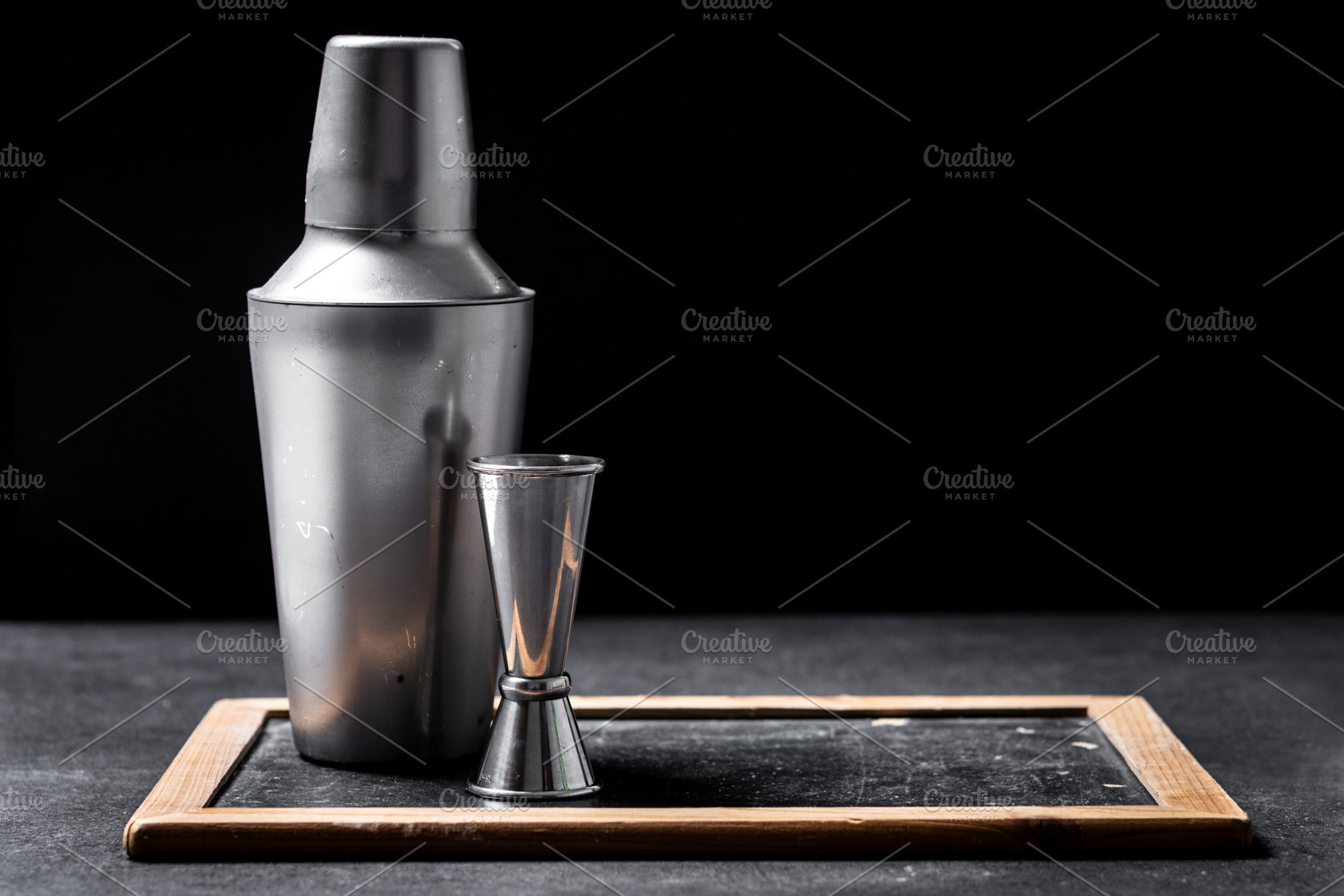 Cocktail shaker and jigger on dark bar background with copy space, a Food & Drink Photo by etorres69