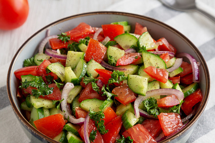 Homemade Mediterranean Cucumber Tomato Salad in a Bowl, side vie, a Food & Drink Photo by LiudmylaChuhunova