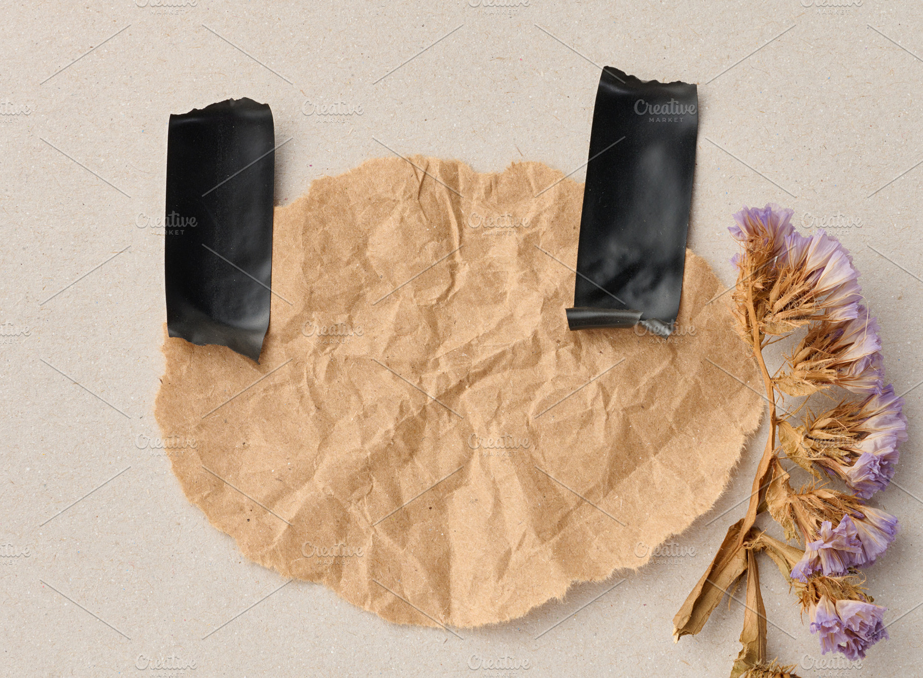 A crumpled sheet of kraft paper on a gray background, secured wi, an Abstract Photo by ndanko