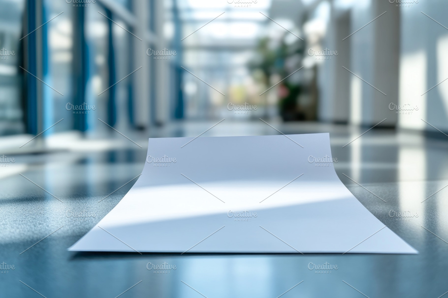A close-up view of a blank sheet of paper lying on a polished floor in a modern, a Background Photo by ImageMir