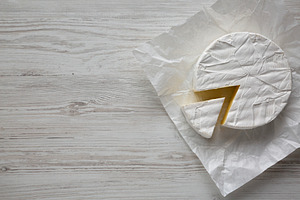 Homemade White Brie Cheese on a Wooden Board, top view. Copy spa, a Food & Drink Photo by LiudmylaChuhunova