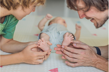 Father, son, and newborn baby lying