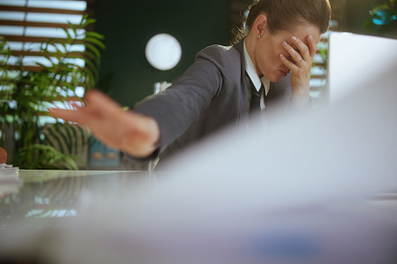 stressed woman worker in green office throwing documents, a Business Photo by Alliance Images
