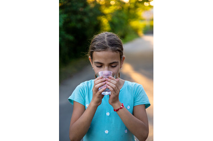 A child drinks water from a glass, a Person Photo by yanadjana