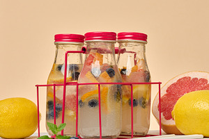 Glass bottles with red lids, filled with detox water infused wit, a Food & Drink Photo by ndanko
