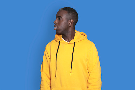 Portrait of cheerful young african-american guy wearing yellow hoodie sweater p, a Person Photo by RF Images