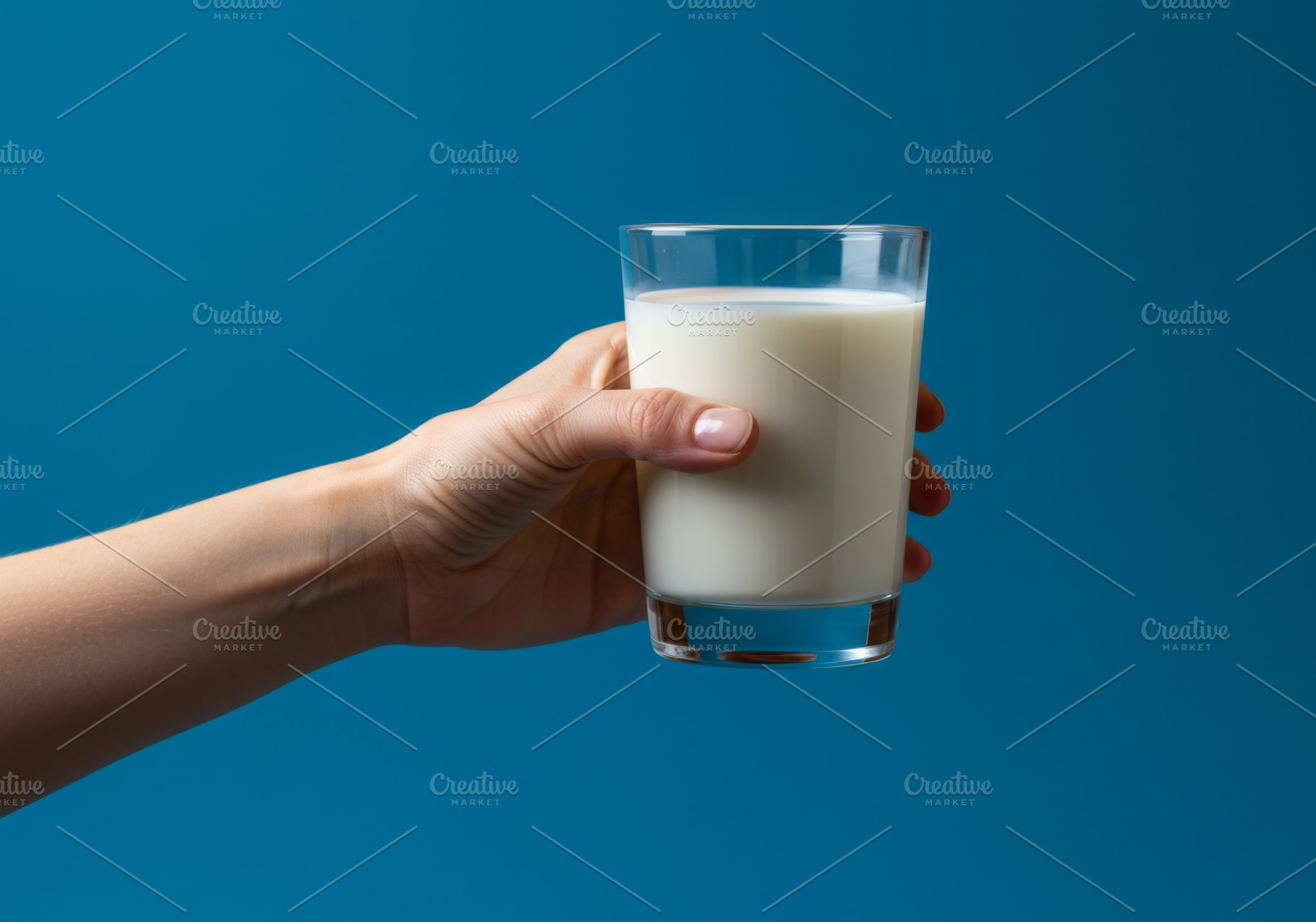 Hand holding a clear glass of milk a, a Food & Drink Photo by professorinc