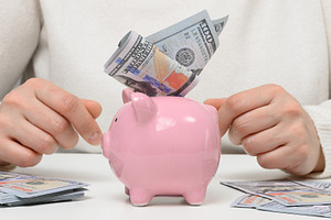 Financial savings, a pink piggy bank with a wad of hundred-dolla, a Business Photo by ndanko