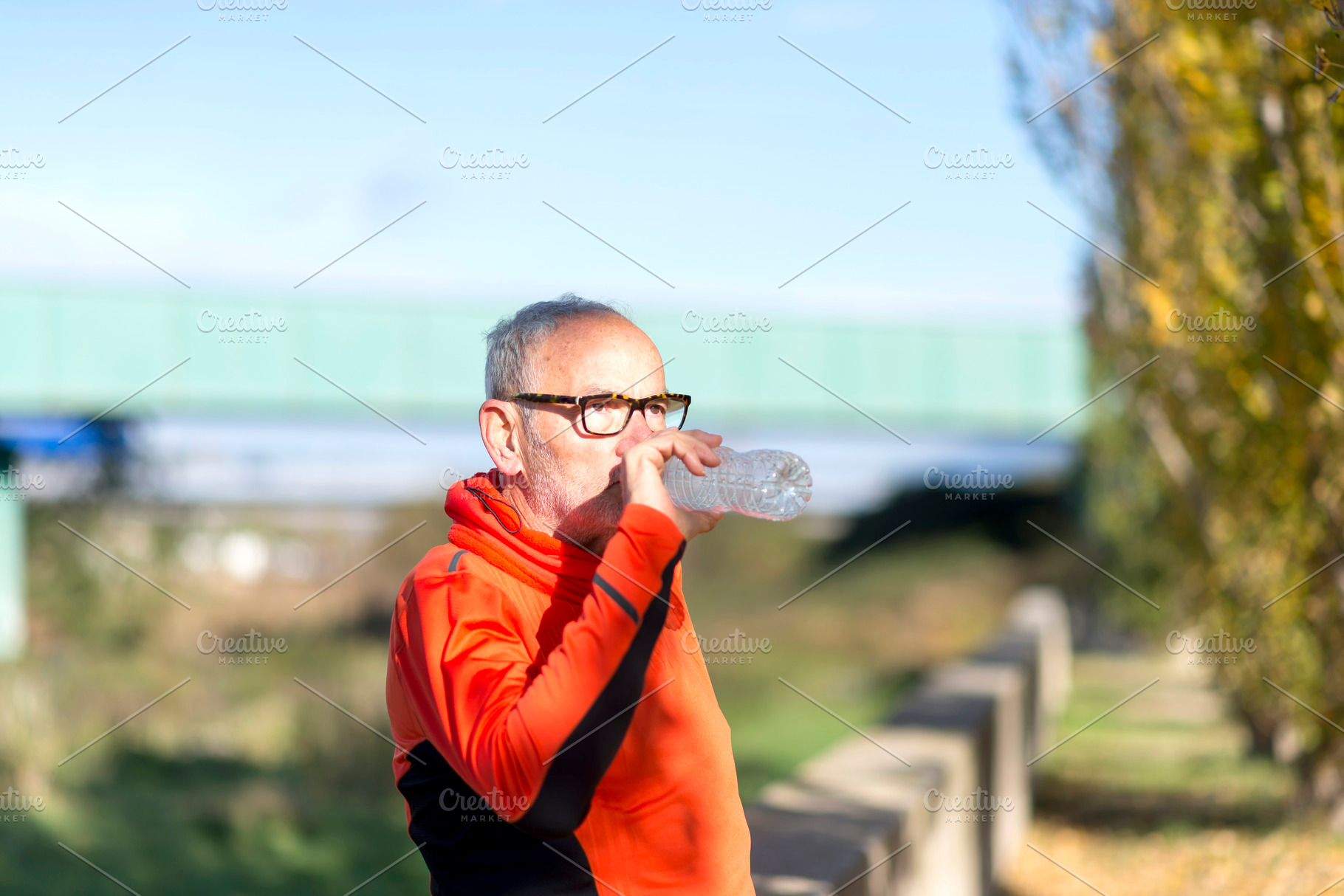 Senior man drinking water after outdoor exercise in nature, a Sports & Recreation Photo by RF Images