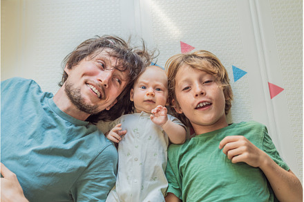 Father, son, and newborn baby lying, a Person Photo by Elizaveta Galitskaya