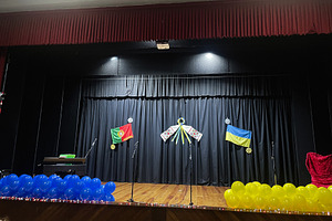 Decorated stage with flags and balloons symbolizing countries at cultural event, a Photo by AS photostudio