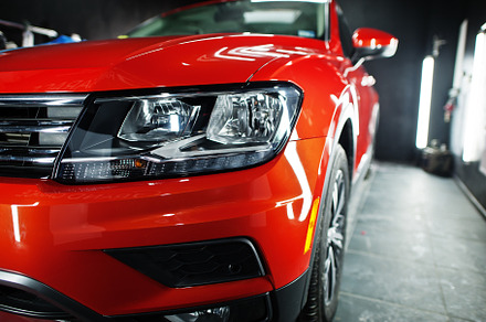 Headlight of nice and new orange sport suv car in modern garage., a Transportation Photo by AS photostudio