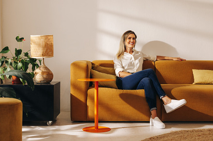 Happy businesswoman sitting on a couch in an office lobby, a Person Photo by Jacob Lund