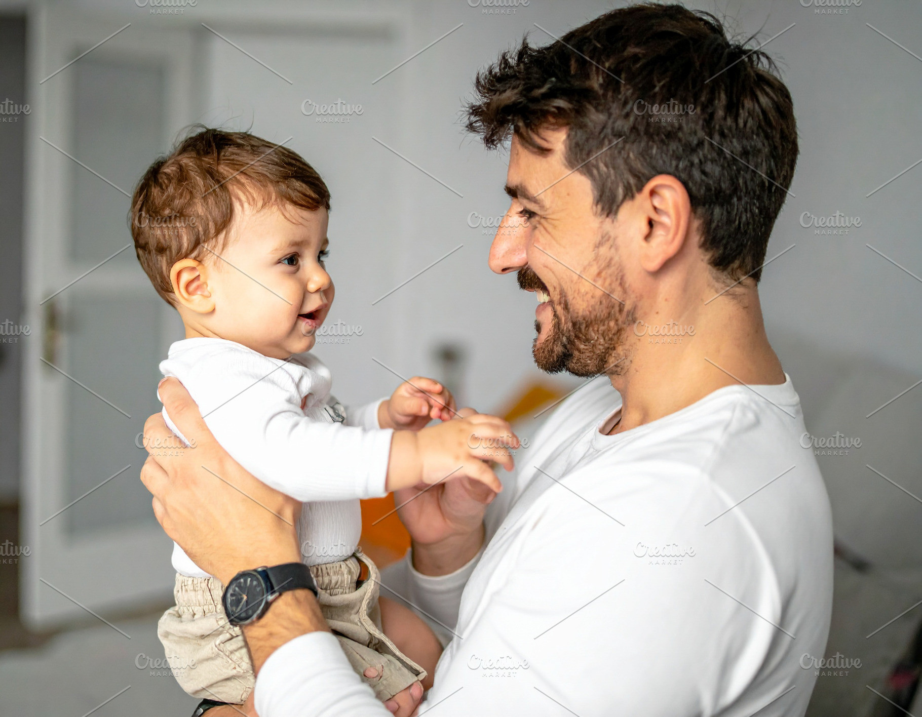 Dad holding in his arm his child at interior scene home, a Person Photo by DanFLCreativo