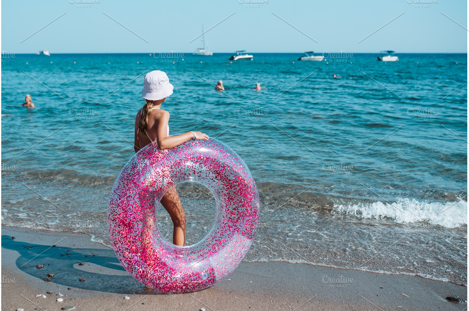 Girl on beach with swim ring during, a Sports & Recreation Photo by HalfPoint