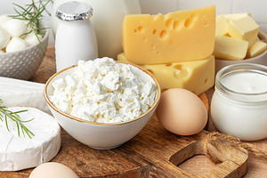 Assortment of fresh dairy products and eggs on wooden board, a Food & Drink Photo by Olena Rudo