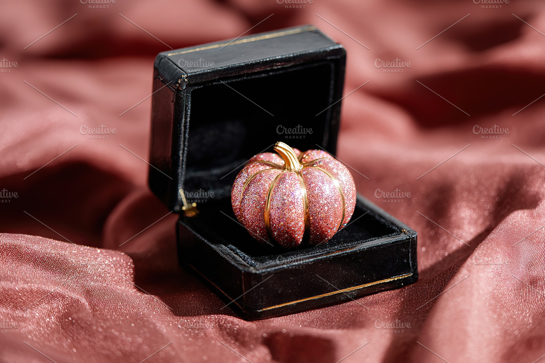 Glossy pumpkin placed elegantly in a small black box on rich fabric backdrop, a Holiday Photo by AlyaAnd