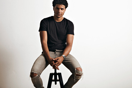 Portrait of a handsome man in black tshirt sitting featuring t-shirt, a Person Photo by DeRepente
