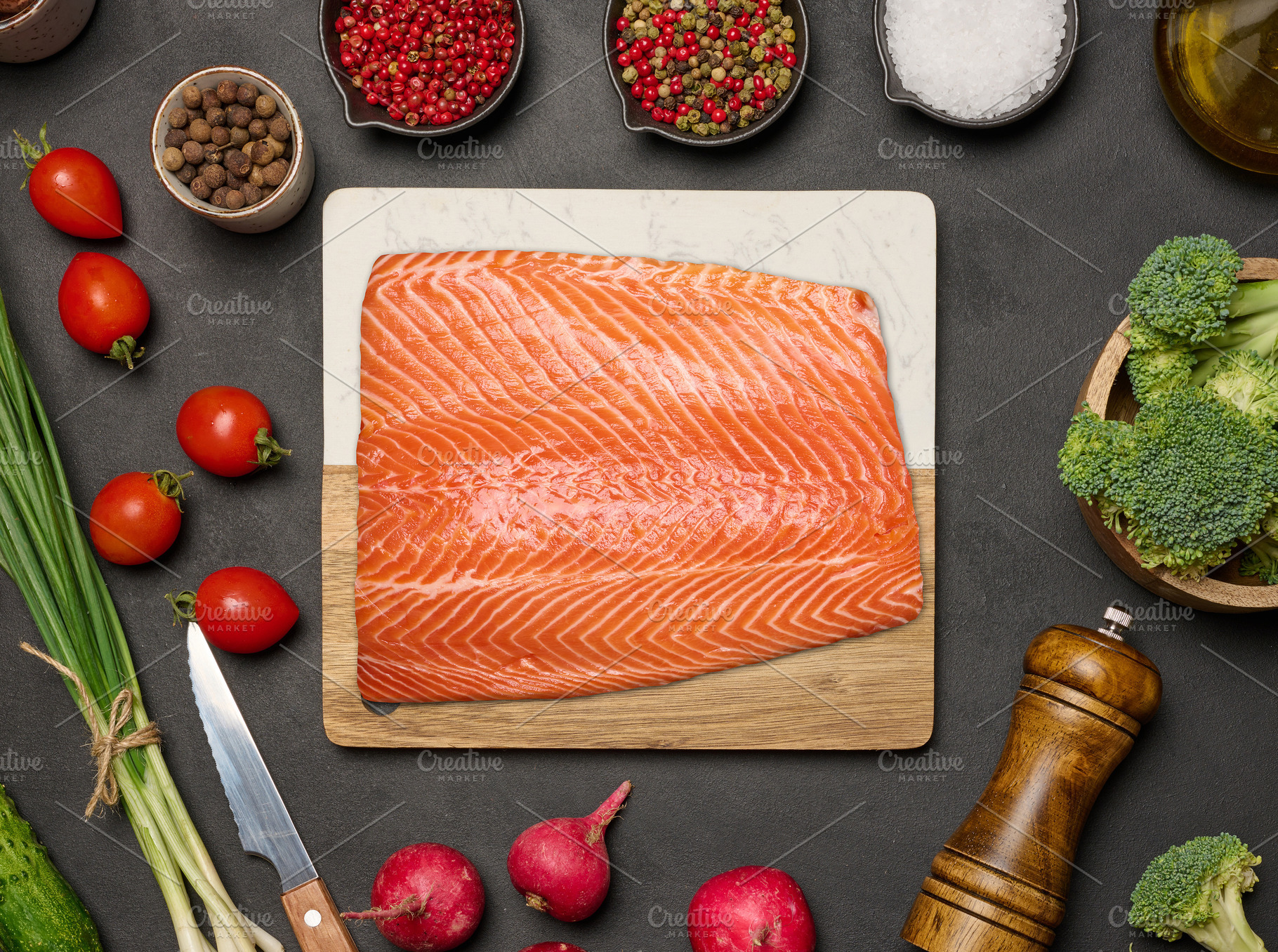 Fresh salmon fillet on a cutting board surrounded by vegetables,, a Food & Drink Photo by ndanko