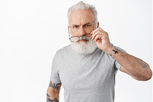 Suspicious old man with tattoos