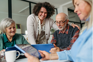 Tutor teaching seniors about phone, a Technology Photo by HalfPoint
