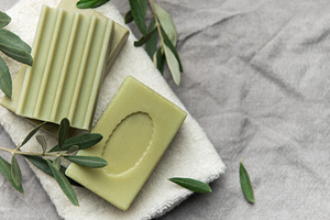 Natural olive soap bars resting on soft white towel with fresh o, a Beauty & Fashion Photo by Olena Rudo