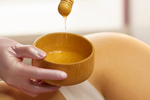 Gloved therapist lifts honey mixture, a Health & Medical Photo by Elena Vagengeim