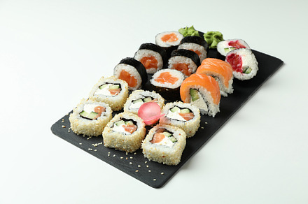 Slate board with sushi set on white background, a Food & Drink Photo by AtlasStudio PRO