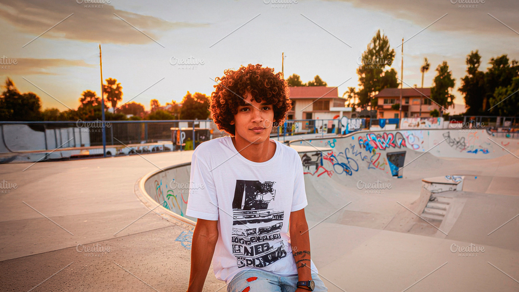 Curly haired teenager at community skatepark, a Person Photo by DanFLCreativo