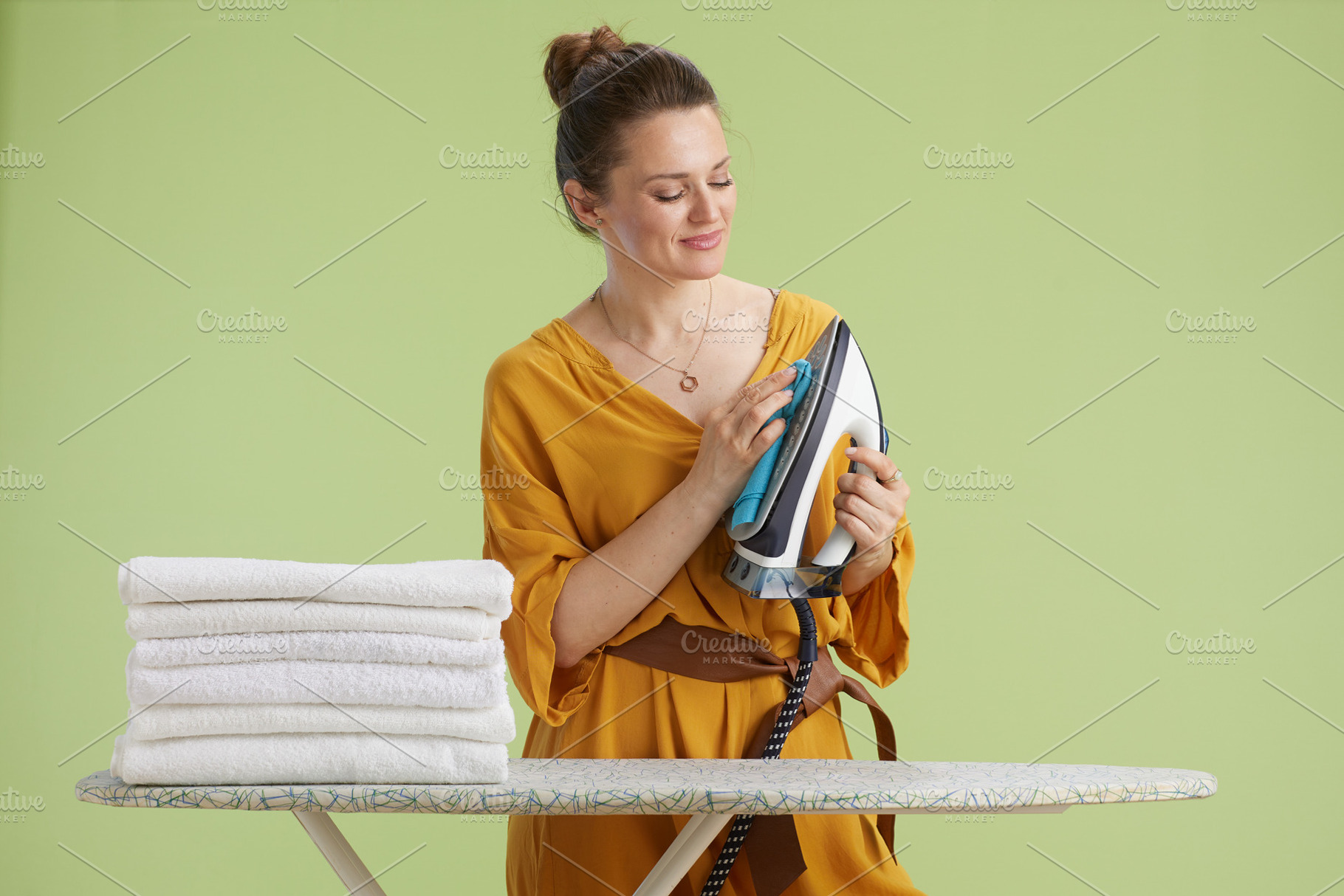 Woman wiping iron with cloth during chores, a Person Photo by Alliance Images