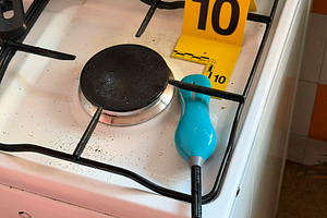 Forensic investigation marking evidence on kitchen gas stove