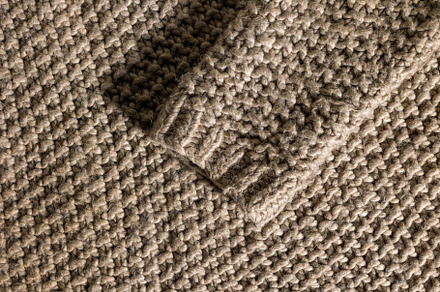 Wool sweater sleeve on texture background