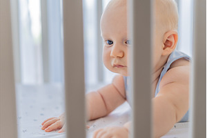 Sad baby looking through the bars of, a Person Photo by Elizaveta Galitskaya