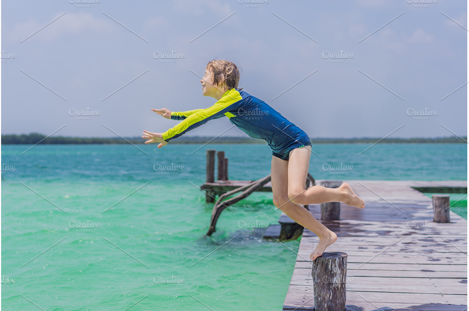 Boy jumping off a pier into a, a Holiday Photo by Elizaveta Galitskaya