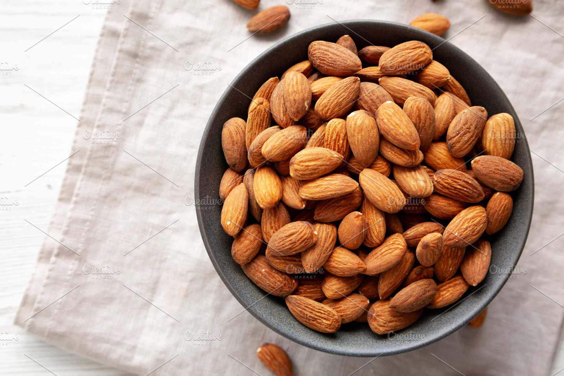 Roasted Almonds in a Bowl, top view. Space for text., a Food & Drink Photo by LiudmylaChuhunova