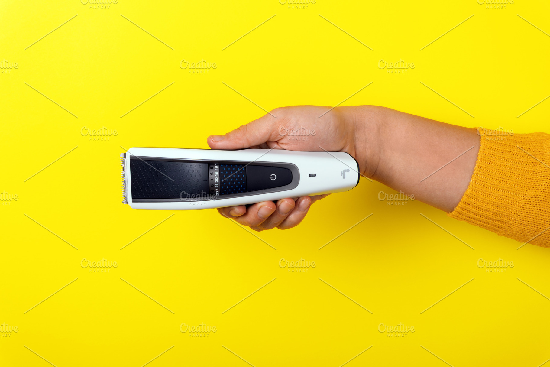 Hand holding an electric hair trimmer horizontally against bold, a Technology Photo by Ales Munt