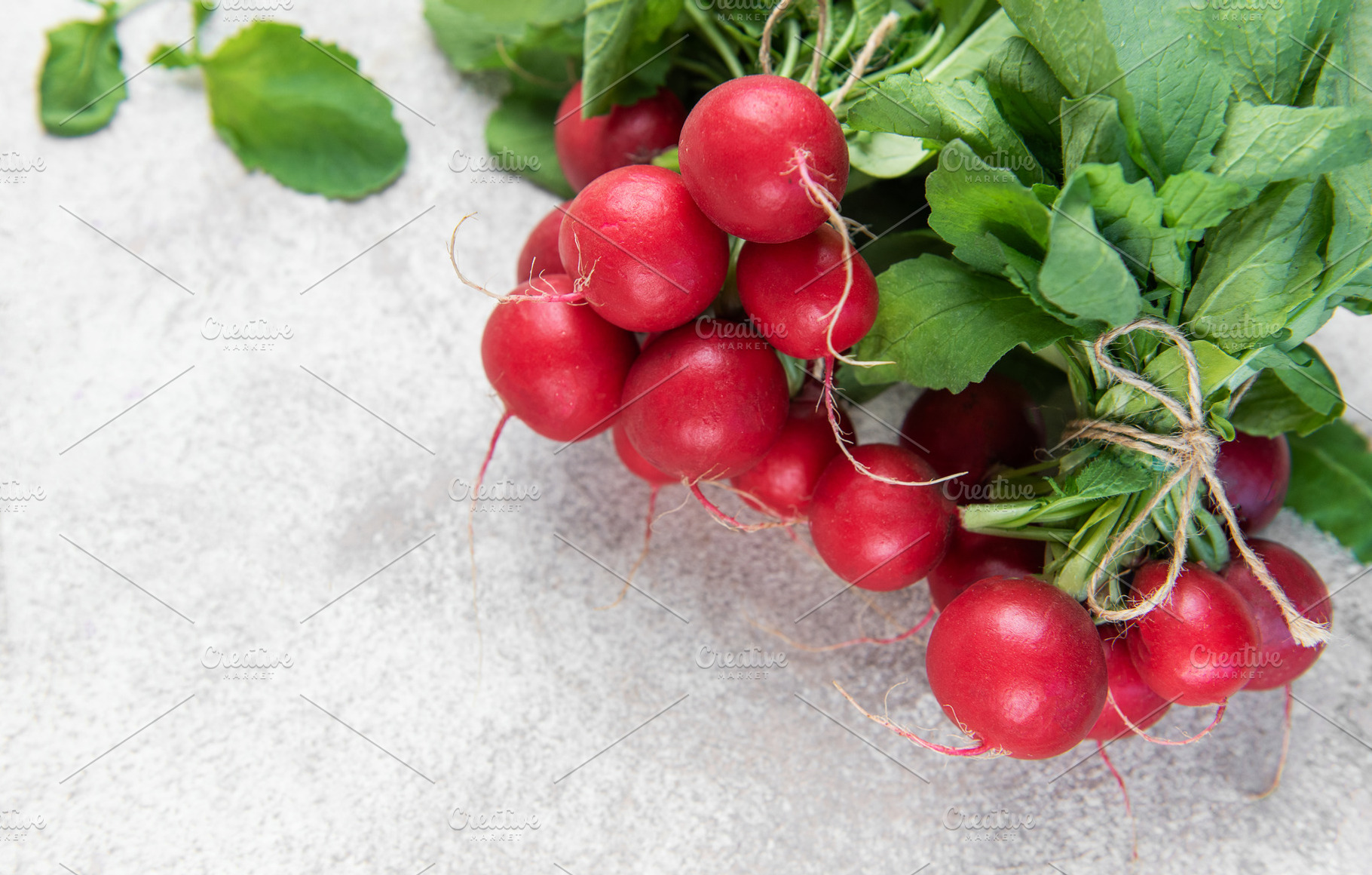 Fresh organic radishes with green leaves on light background, a Food & Drink Photo by Olena Rudo